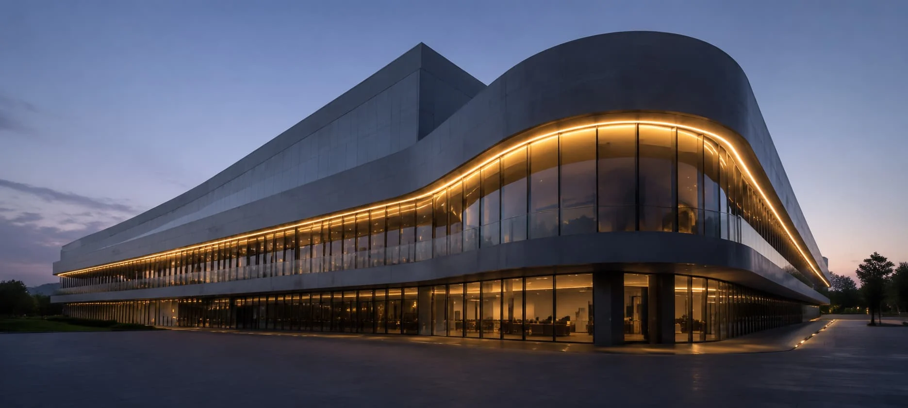 Continuous warm light following the curved edge of a glazed building at dusk